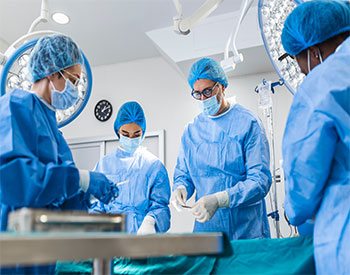Multi-ethnic healthcare workers performing surgery on patient at operation theater.